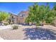 Attractive front yard showcasing desert landscaping and a well-maintained lawn and mature tree at 46057 W Dutchman Dr, Maricopa, AZ 85139