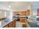 Stylish kitchen featuring wooden cabinets, sleek countertops, and open access to dining area at 46057 W Dutchman Dr, Maricopa, AZ 85139