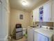 A well lit laundry room features white cabinets above front loading washer dryer at 46057 W Dutchman Dr, Maricopa, AZ 85139