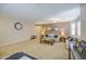Comfortable living room with a large clock on the wall, neutral carpet, and a seating arrangement at 46057 W Dutchman Dr, Maricopa, AZ 85139