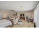 Spacious main bedroom featuring a ceiling fan, sitting area, and comfortable furnishings at 46057 W Dutchman Dr, Maricopa, AZ 85139