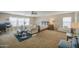 Spacious main bedroom featuring a seating area, carpet, and plenty of natural light from large windows at 46057 W Dutchman Dr, Maricopa, AZ 85139