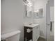 Bathroom with a white vanity, mirror, toilet, gray floors and a dark brown cabinet underneath the sink at 4727 N 50Th Dr, Phoenix, AZ 85031