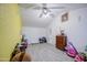 Room with gray floors, yellow accent wall, white ceiling fan, and an assortment of toys at 4727 N 50Th Dr, Phoenix, AZ 85031