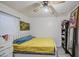 A bedroom featuring a bright window, a ceiling fan, white brick walls, and tile floors at 4727 N 50Th Dr, Phoenix, AZ 85031