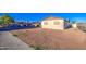 View of the front of the house with a gravel yard, covered parking, and a chain link fence at 4727 N 50Th Dr, Phoenix, AZ 85031