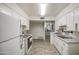 Efficient kitchen layout with white appliances, cabinets, and tile flooring leading into an additional room at 4727 N 50Th Dr, Phoenix, AZ 85031