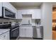 Bright kitchen features white cabinets, stainless steel appliances, and sleek countertops at 4901 S Calle Los Cerros Dr # 237, Tempe, AZ 85282