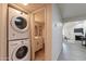 Convenient laundry area with stacked washer and dryer, located near a hallway and a well-lit bathroom at 4901 S Calle Los Cerros Dr # 237, Tempe, AZ 85282