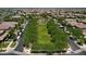 Aerial view of a neighborhood, featuring a green space with trees lining the street at 5223 S Axiom --, Mesa, AZ 85212