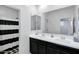Modern bathroom featuring a double sink vanity with black cabinets and a shower with a striped curtain at 5223 S Axiom --, Mesa, AZ 85212