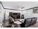 Comfortable living room with dark leather couches, black trim, and modern ceiling fan at 5223 S Axiom --, Mesa, AZ 85212