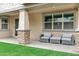 Comfortable covered patio with stylish seating, stone supports, and manicured artificial lawn at 5223 S Axiom --, Mesa, AZ 85212