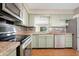 A well-lit kitchen with granite counters, stainless steel appliances and ample cabinet space at 612 N Recker Rd, Mesa, AZ 85205