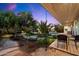 The backyard features a stone patio, outdoor furniture, trees, shrubbery, and seamless access to the house at 6417 N 52Nd Pl, Paradise Valley, AZ 85253