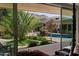 Relaxing backyard pool area with lush landscaping and inviting seating, visible through sliding glass doors at 6417 N 52Nd Pl, Paradise Valley, AZ 85253