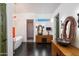 This modern bathroom includes designer lighting fixtures, stylish vanities and a soaking tub under a picture window at 6417 N 52Nd Pl, Paradise Valley, AZ 85253