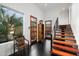 Inviting foyer featuring black tile floors, wood doors and staircase, and a bright window with outdoor views at 6417 N 52Nd Pl, Paradise Valley, AZ 85253
