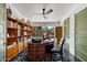 Stylish office with wood floors, bookshelves, an oval desk, and a large window overlooking the lush backyard at 6417 N 52Nd Pl, Paradise Valley, AZ 85253