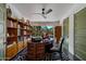 Well-lit office space with a custom wood desk, built-in shelving, and a view to the exterior landscaped yard at 6417 N 52Nd Pl, Paradise Valley, AZ 85253