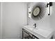 Modern powder room with a unique mirror, decorative lighting, and a minimalist sink and countertop at 6417 N 52Nd Pl, Paradise Valley, AZ 85253