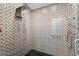The shower is fitted with modern fixtures and is fully tiled in a geometric pattern from floor to ceiling at 6417 N 52Nd Pl, Paradise Valley, AZ 85253