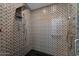 Beautiful walk-in shower features custom geometric tile work, a rainfall shower head, and glass doors at 6417 N 52Nd Pl, Paradise Valley, AZ 85253