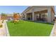 Well-maintained backyard featuring artificial grass, patio, BBQ grill, and a play structure for outdoor entertaining at 6422 W Brookhart Way, Phoenix, AZ 85083