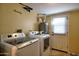 Bright laundry room featuring a washer, dryer, water heater and convenient access to the outside at 6901 E Portland St, Scottsdale, AZ 85257