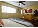 Well-lit main bedroom with a ceiling fan, dresser, and a view into an en-suite bathroom at 6901 E Portland St, Scottsdale, AZ 85257