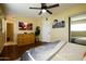 Spacious bedroom featuring a ceiling fan, dresser, closet, and stylish decor with easy access to the bathroom at 6901 E Portland St, Scottsdale, AZ 85257