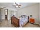 This bedroom features a ceiling fan, mirrored closet, a bed, and an end table with a plant on top at 7125 W Canterbury Dr, Peoria, AZ 85345