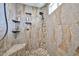 Modern stone shower features pebble flooring, built-in shelves, and adjustable shower head at 7125 W Canterbury Dr, Peoria, AZ 85345