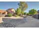 Spacious backyard with drought-tolerant landscaping and a dry creek bed, complete with privacy fencing at 7977 W Wacker Rd # 253, Peoria, AZ 85381