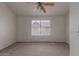 Carpeted bedroom featuring a ceiling fan and a large window at 7977 W Wacker Rd # 253, Peoria, AZ 85381