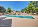 Community pool area is surrounded by trees and buildings, providing a refreshing space for residents at 7977 W Wacker Rd # 253, Peoria, AZ 85381