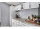 Close up of kitchen details, featuring white cabinets, countertop accessories, and neutral countertop at 8107 E Butte St, Mesa, AZ 85207
