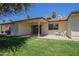 Backyard view with covered patio, grass, and plastic chairs at 8261 E Keats Ave # 396, Mesa, AZ 85209