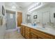 Well-lit bathroom featuring double sinks, wooden cabinets, and a glass-enclosed shower at 8261 E Keats Ave # 396, Mesa, AZ 85209