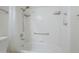 Bathroom shower and tub with tiled walls, shower head, and storage shelves at 8261 E Keats Ave # 396, Mesa, AZ 85209