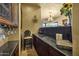 Home bar with black granite countertops, pendant lights, ornate stool, and wine glass storage at 9290 E Thompson Peak Pkwy # 409, Scottsdale, AZ 85255
