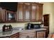 Luxurious bar area featuring dark wood cabinets, granite countertops, and modern appliances at 9290 E Thompson Peak Pkwy # 409, Scottsdale, AZ 85255