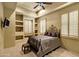 Cozy bedroom with neutral colors, decorative wrought iron bed frame, and built in shelves and window seats at 9290 E Thompson Peak Pkwy # 409, Scottsdale, AZ 85255