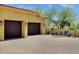 Two-car garage with dark doors and a paver driveway at 9290 E Thompson Peak Pkwy # 409, Scottsdale, AZ 85255