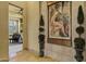 Elegant hallway with travertine floors, decorative plants, and a striking wall mural, creating a sophisticated ambiance at 9290 E Thompson Peak Pkwy # 409, Scottsdale, AZ 85255