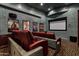 Cozy home theater with red leather recliners, movie posters, and a large screen for ultimate entertainment at 9290 E Thompson Peak Pkwy # 409, Scottsdale, AZ 85255