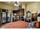 Warm bedroom featuring a wet bar with a granite countertop and dark wood cabinetry, adjacent to a bathroom at 9290 E Thompson Peak Pkwy # 409, Scottsdale, AZ 85255