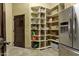 Well-organized pantry with custom shelving and stainless steel refrigerator, offering ample storage space at 9290 E Thompson Peak Pkwy # 409, Scottsdale, AZ 85255