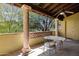 Covered patio featuring stone columns, tile flooring, and a glass table set for outdoor relaxation at 9290 E Thompson Peak Pkwy # 409, Scottsdale, AZ 85255