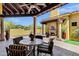Covered outdoor patio featuring a stone fireplace, ceiling fan, and comfortable seating near the pool at 9290 E Thompson Peak Pkwy # 409, Scottsdale, AZ 85255
